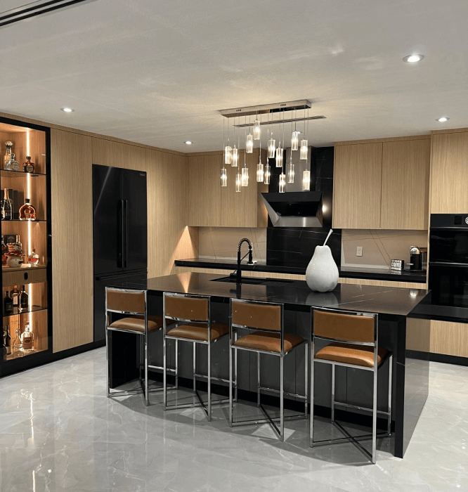 Modern kitchen with black marble island, pendant lighting, and wooden cabinets