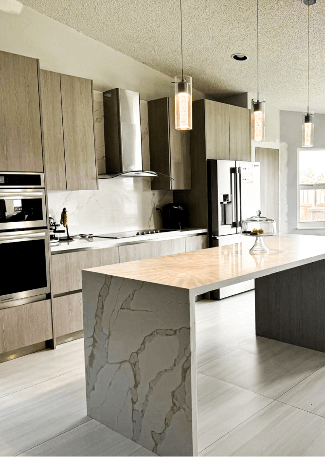 Modern kitchen with marble island, wooden cabinets, and pendant lights