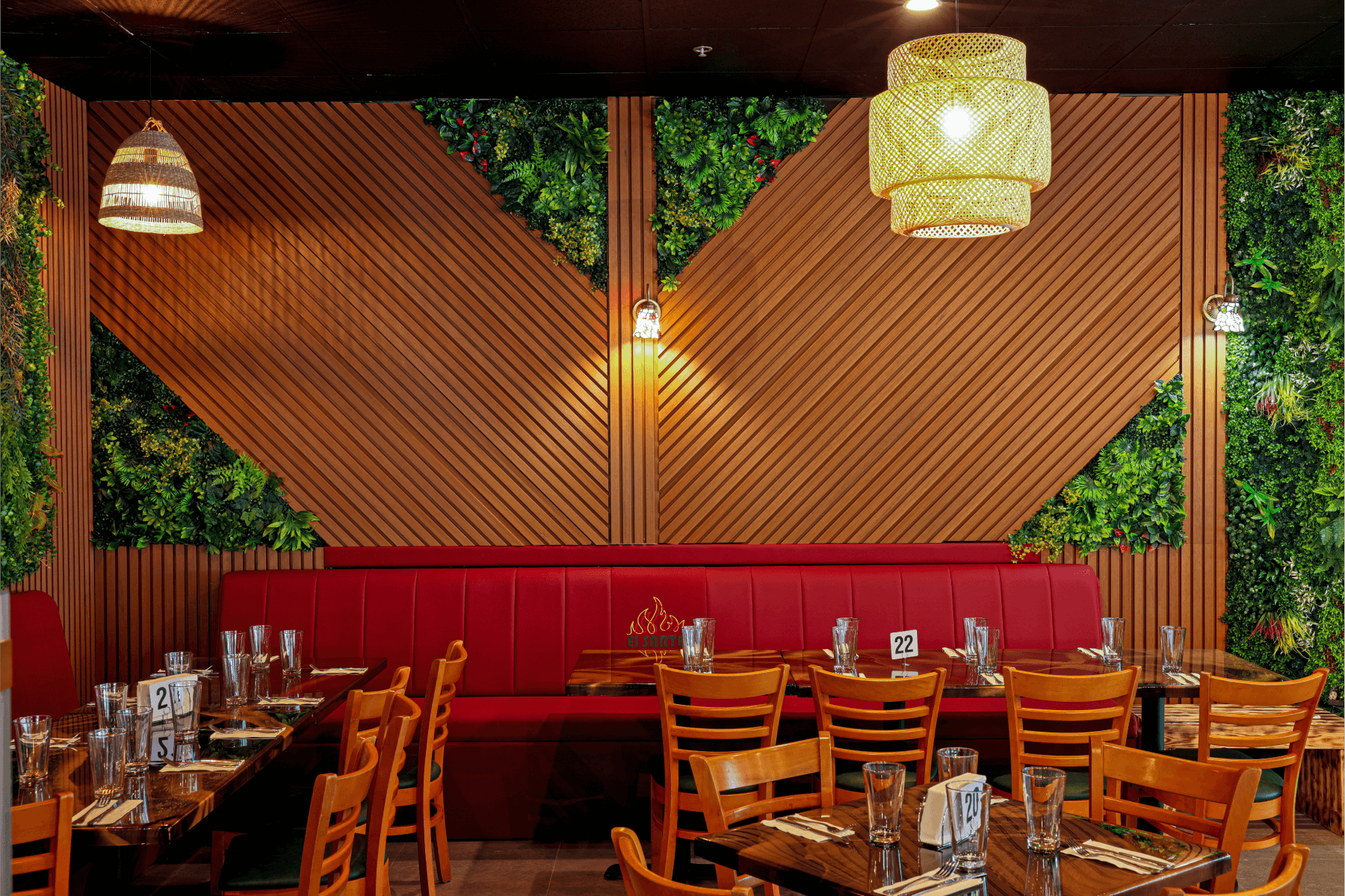 Restaurant seating area with red booth, wooden accents, and green wall decor