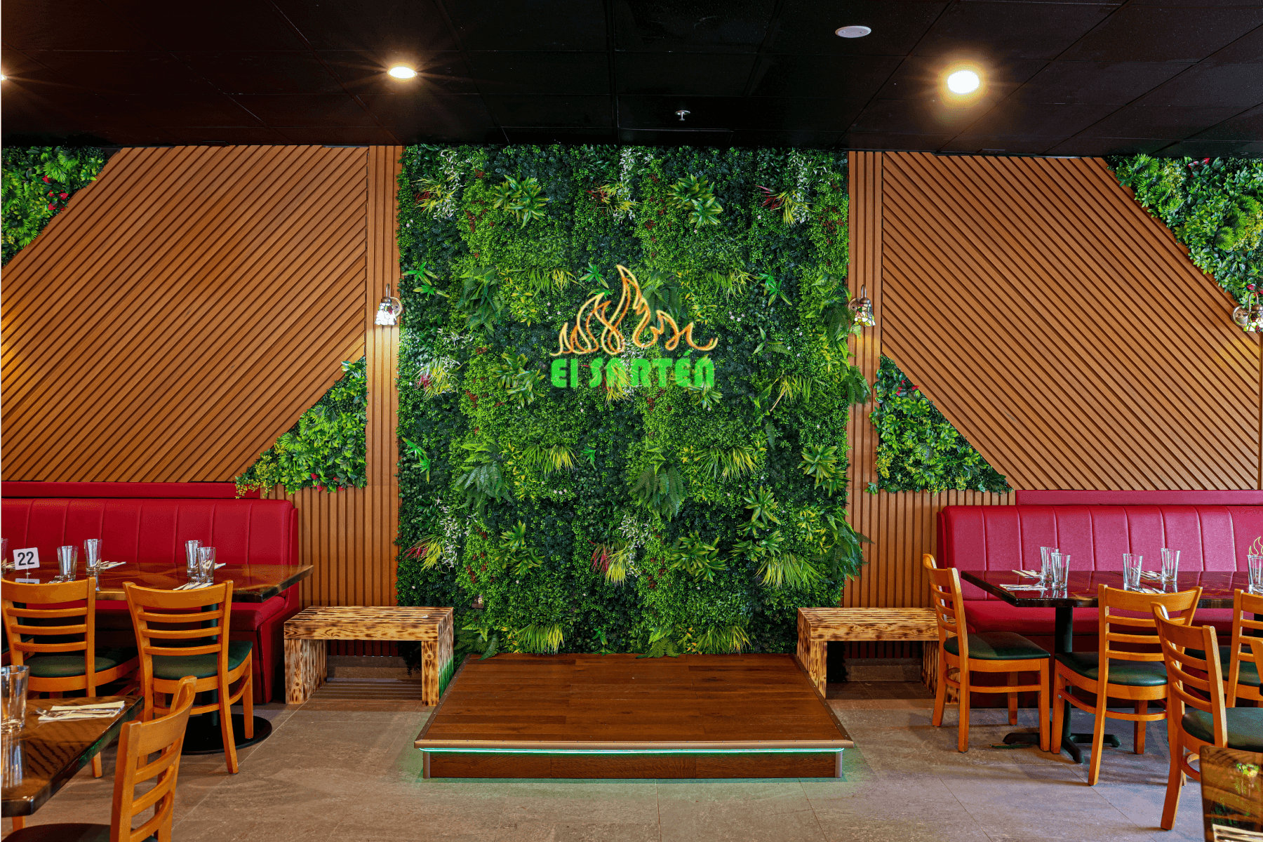 Restaurant interior with green wall, wooden accents, and red booth seating at El Sartén