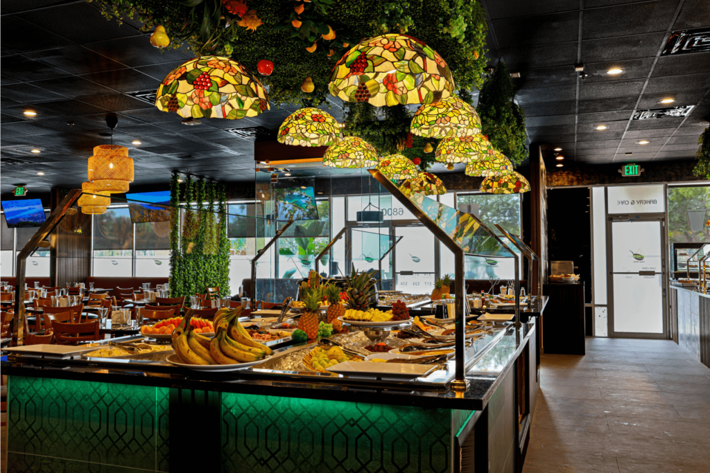 Buffet station with fresh fruits, stained glass pendant lights, and greenery decor