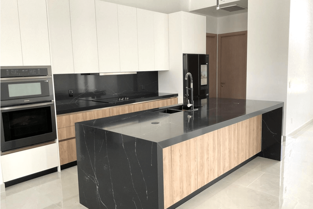 Minimalist kitchen with black marble island, wooden cabinets, and built-in appliances